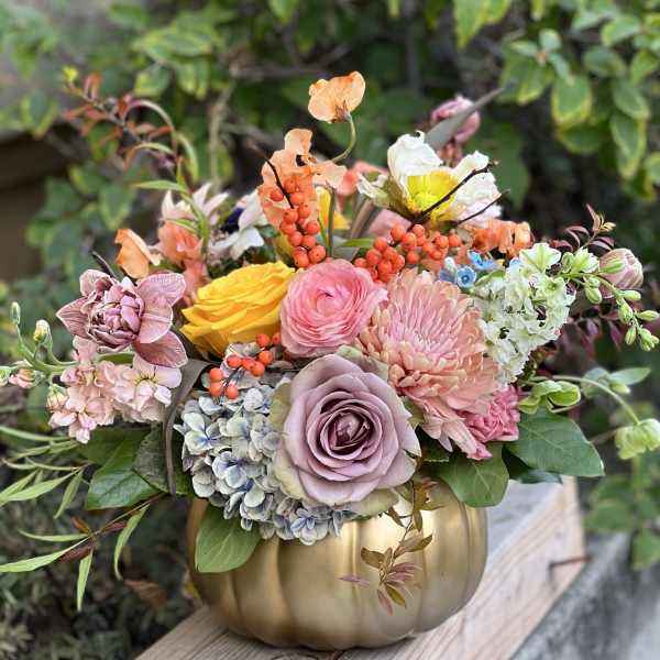 Mixed pastel bouquet in a gold pumpkin vase