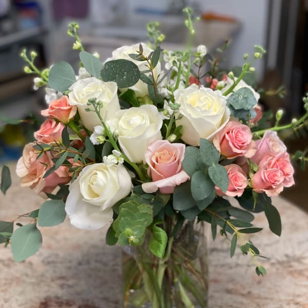 White and pink roses in a clear glass vase