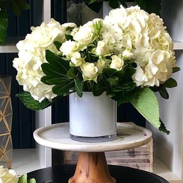 White hydrangea and rose arrangement in a white vase