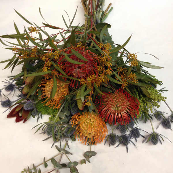 Mixed bouquet with red, orange, and yellow pincushion-like blooms