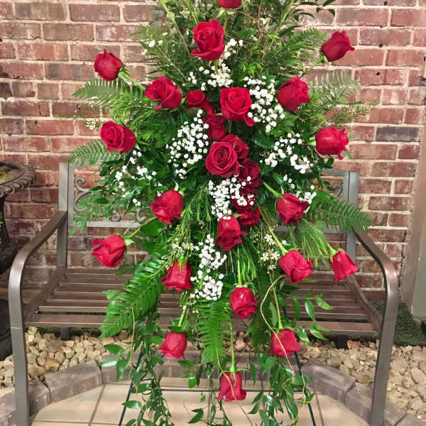 Tall standing arrangement of red roses with white baby's breath