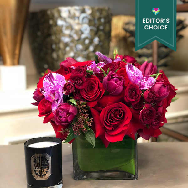 Red and pink rose bouquet in a square glass vase