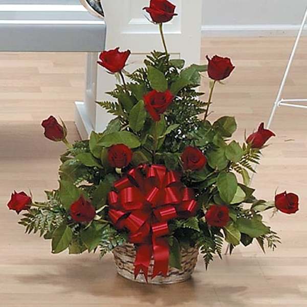 Basket arrangement of red roses with a large red bow