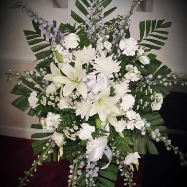Large white floral standing spray with lilies and chrysanthemums