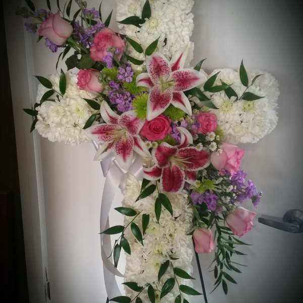 Cross-shaped floral spray with white blooms, pink roses, and lilies
