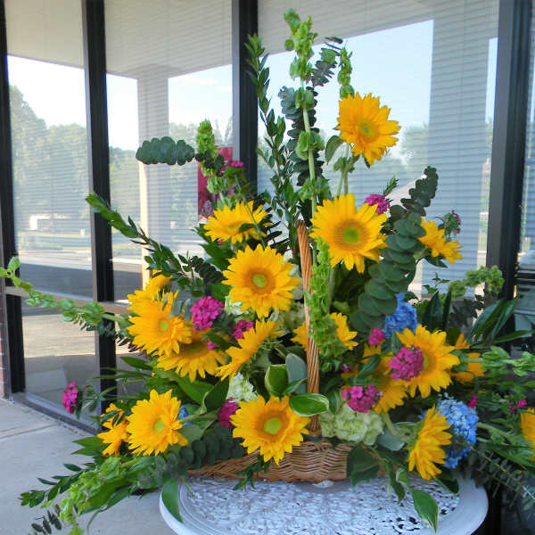 Basket arrangement with yellow sunflowers and mixed greenery