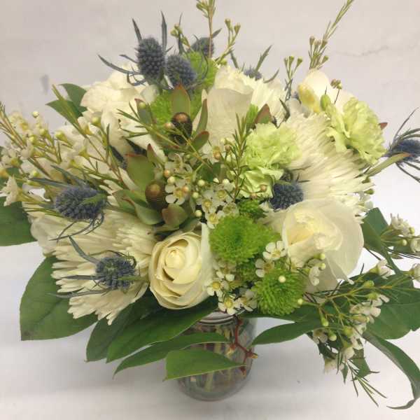 White and green bouquet with roses and chrysanthemums in a glass vase