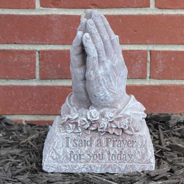 Prayer hands garden statue with floral detail and engraved text