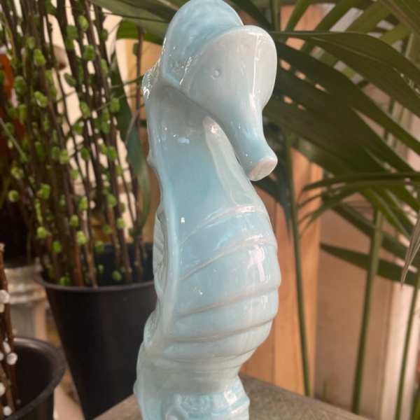 Light blue ceramic seahorse figurine on a table