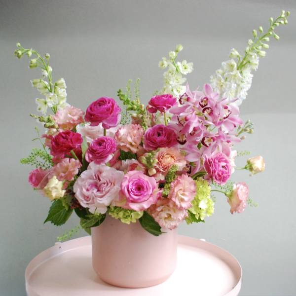 Pink and white floral arrangement in a blush vase