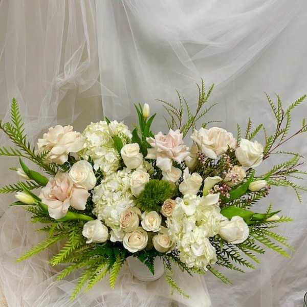 Cream and blush floral arrangement in a white vase
