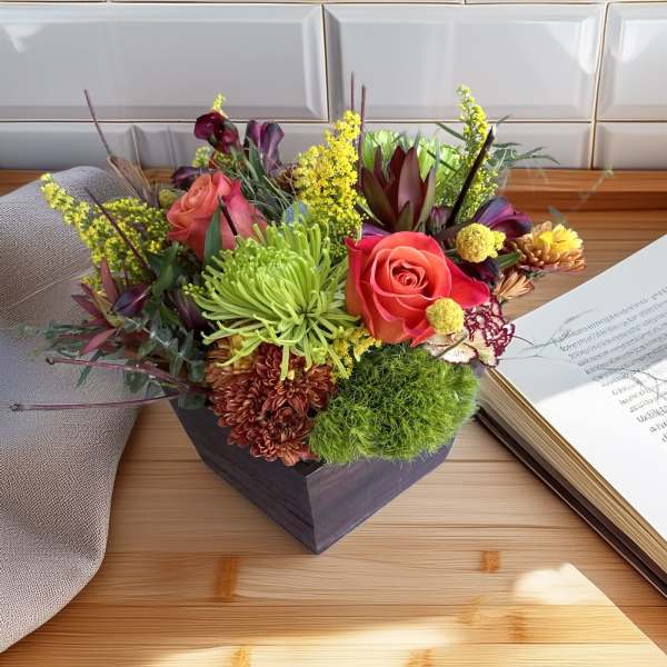 Mixed bouquet with roses and chrysanthemums in a dark square container