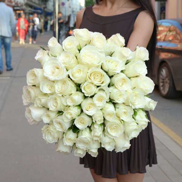 Woman holding a large bouquet of white roses