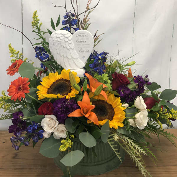 Sympathy arrangement with sunflowers, roses, and an angel plaque