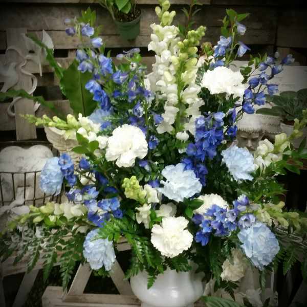Blue and white floral arrangement in a white vase