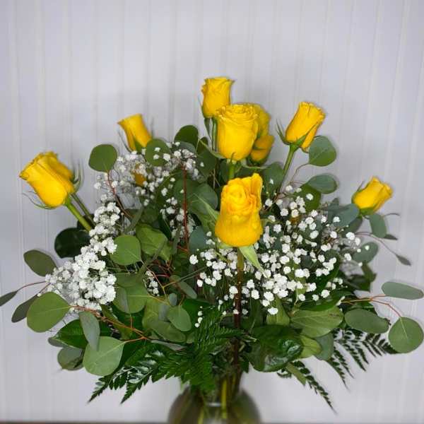 Yellow roses in a glass vase with white baby's breath