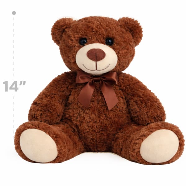 Brown teddy bear with a satin bow sitting on a white background