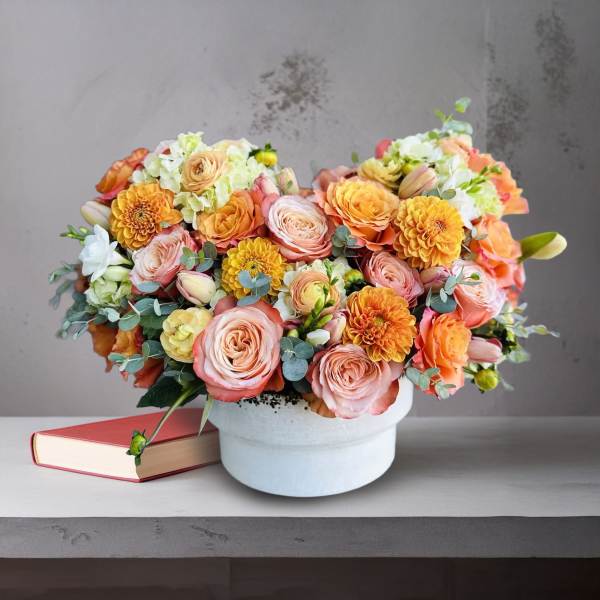 Peach and pink flower arrangement in a white hat box