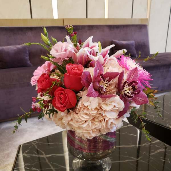 Pink and red floral arrangement in a glass vase