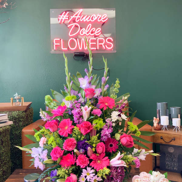 Large mixed bouquet with pink, purple, and white flowers in a basket