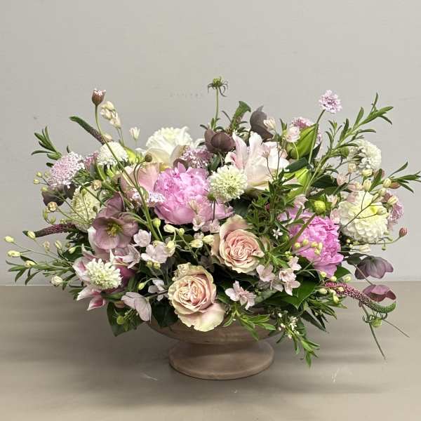 Mixed pink and white floral arrangement in a low pedestal bowl