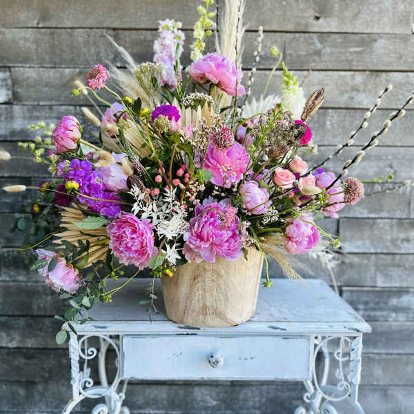 Pink and purple mixed bouquet in a wooden vase