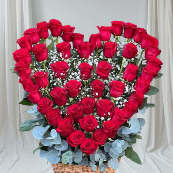 Heart-shaped basket arrangement of red roses with baby's breath