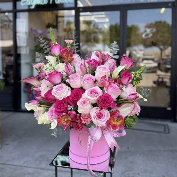 Pink and white rose bouquet in a pink hat box with ribbon