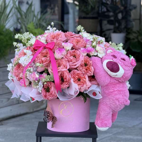 Pink rose bouquet in a pink hat box with a plush teddy bear
