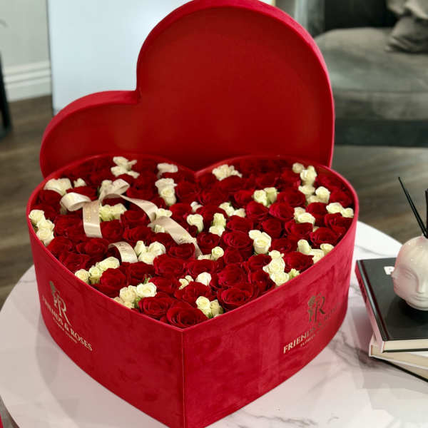 Heart-shaped red box filled with red and white roses