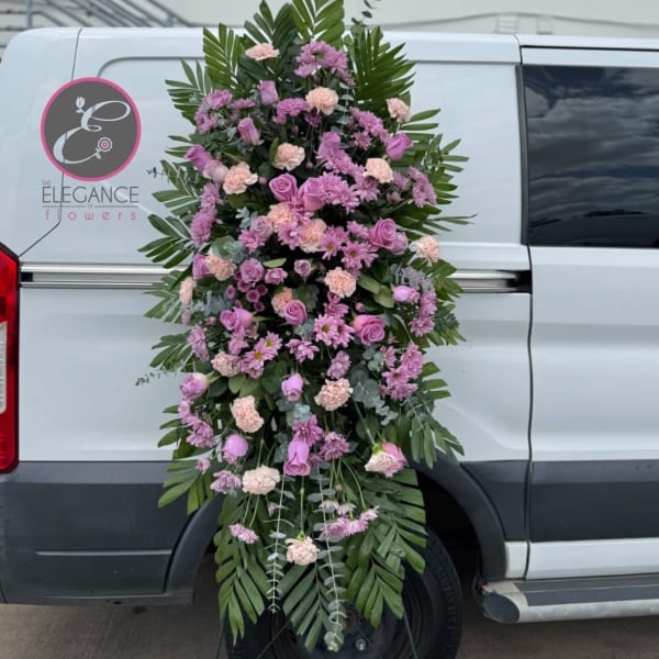 Large pink and lavender funeral spray on a vehicle