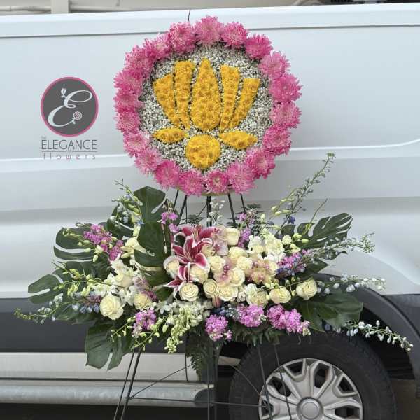 Standing floral tribute with pink and yellow flowers on an easel