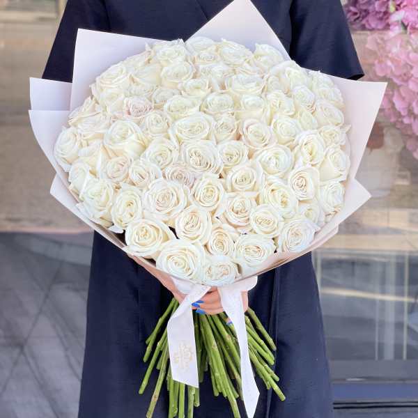 Large bouquet of white roses wrapped in pale paper