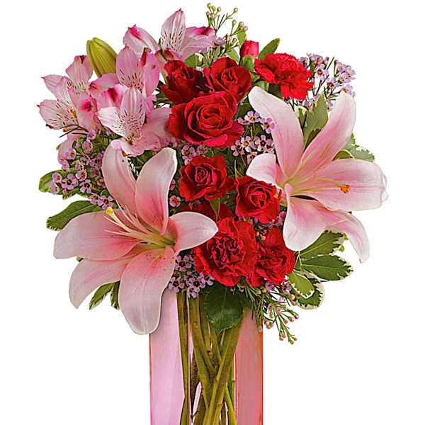 Pink lilies and red roses in a tall glass vase with a pink ribbon