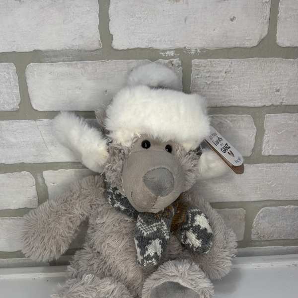 Plush gray teddy bear wearing a white hat and scarf