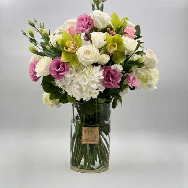Bouquet of white, pink, and green flowers in a clear glass vase