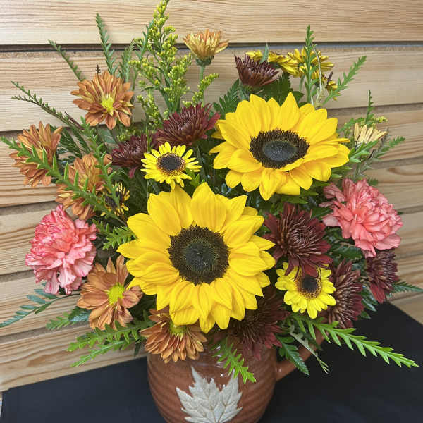 Sunflower and chrysanthemum arrangement in a brown ceramic vase