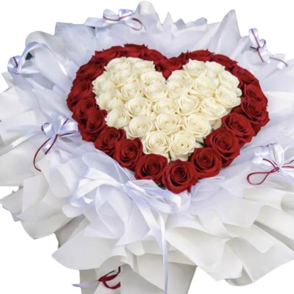 Heart-shaped bouquet of red and white roses wrapped in white paper
