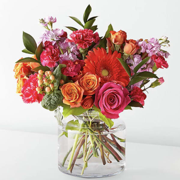 Mixed bouquet of roses, gerbera daisy, and carnations in a glass vase