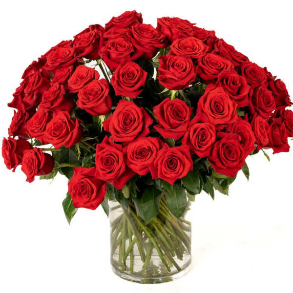 Large bouquet of red roses arranged in a clear glass cylinder vase