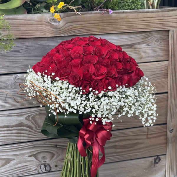 Large bouquet of red roses with white baby's breath and ribbon