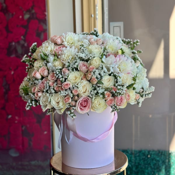 Large bouquet of pink and white roses in a round box