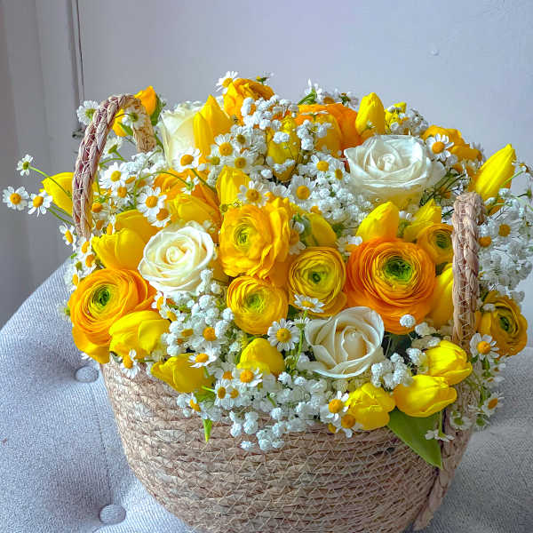 Yellow and white flower arrangement in a woven basket