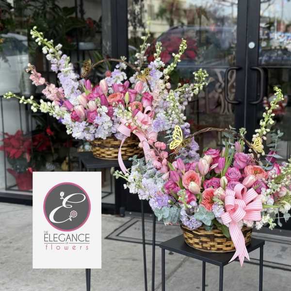 Two pastel flower baskets with pink ribbons and butterfly picks