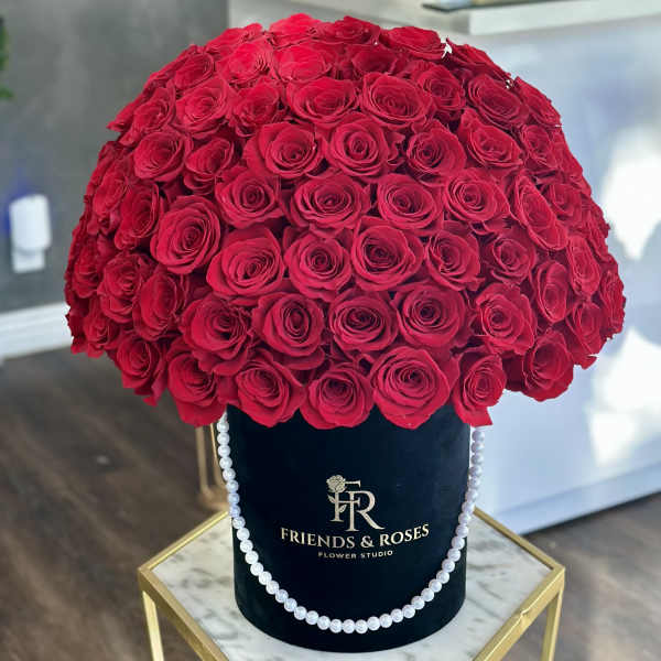 Large dome of red roses in a black hatbox with pearl trim
