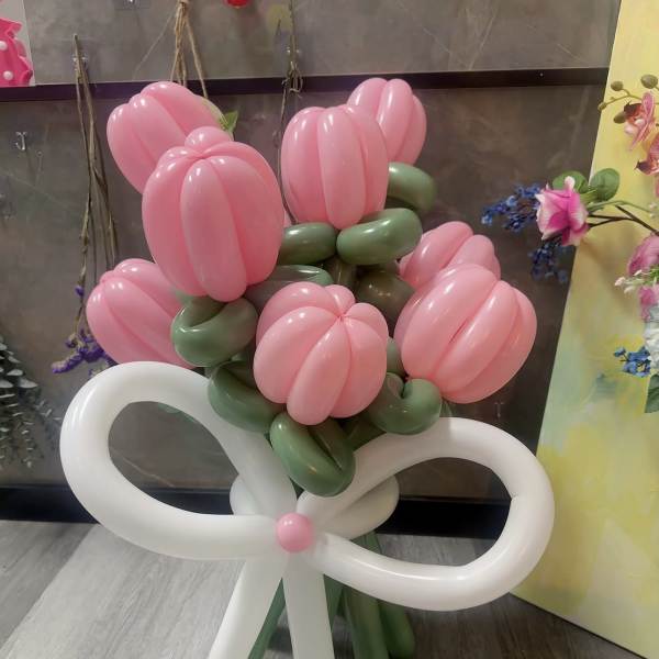 Pink balloon bouquet tied with a large white bow