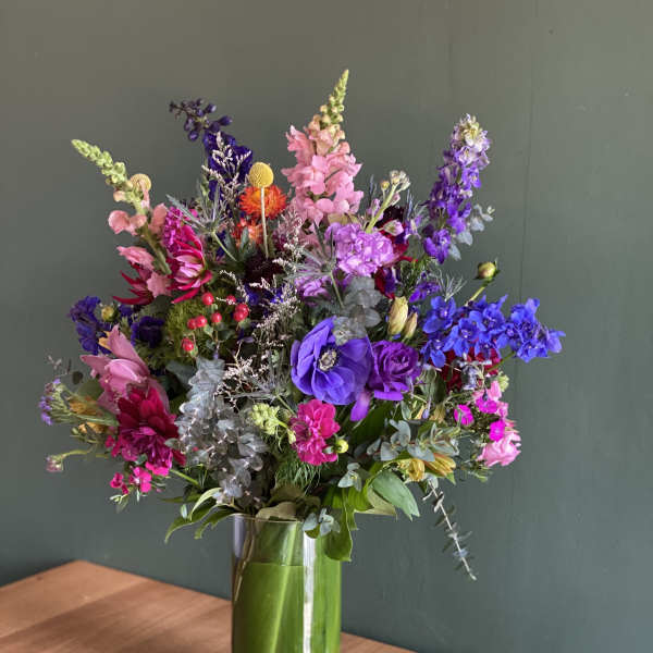 Colorful mixed bouquet in a tall glass vase