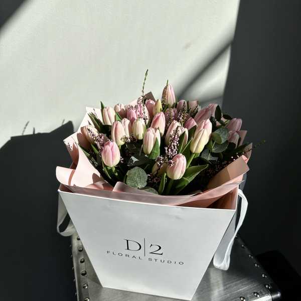 Pink tulip bouquet in a white gift bag
