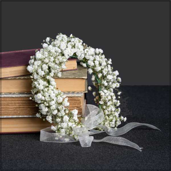 White baby's breath floral wreath with a sheer ribbon