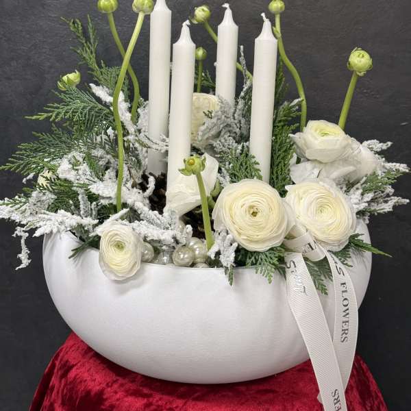 White floral arrangement with candles in a bowl-shaped vase